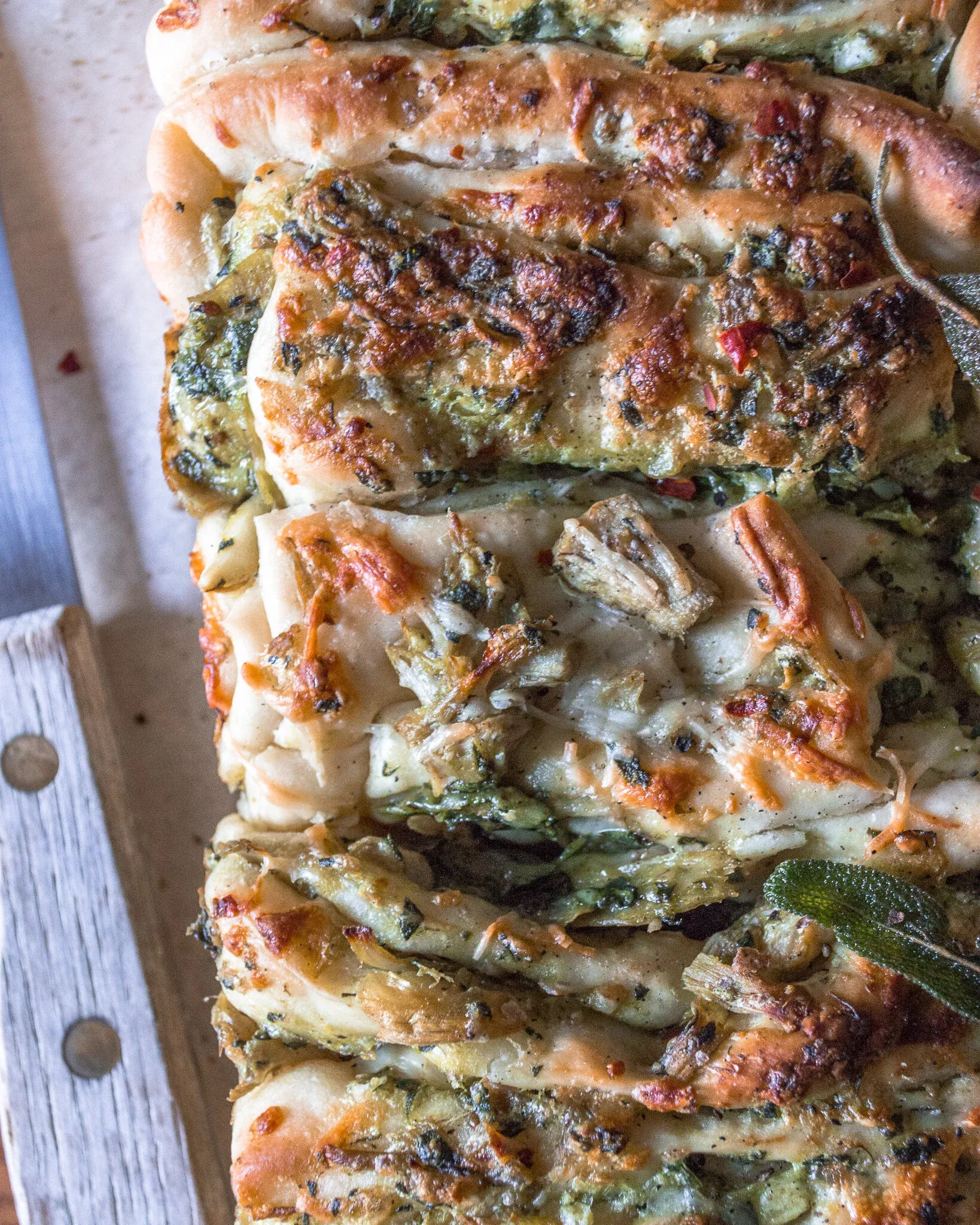 Extreme close-up overhead view of the cheesy spinach and artichoke pull-apart bread from above one end