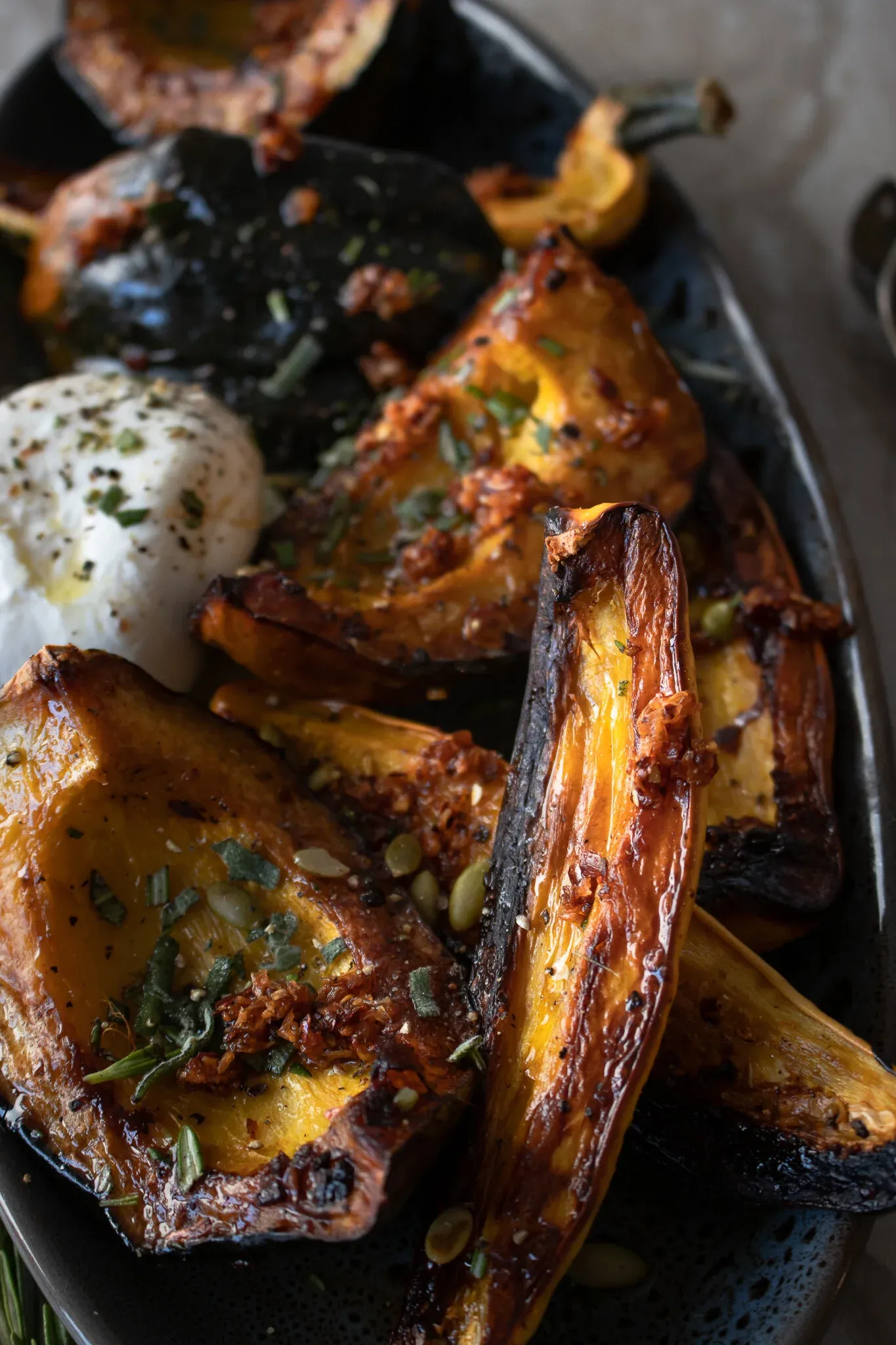 Close angled side shot of maple roasted squash on the dark platter