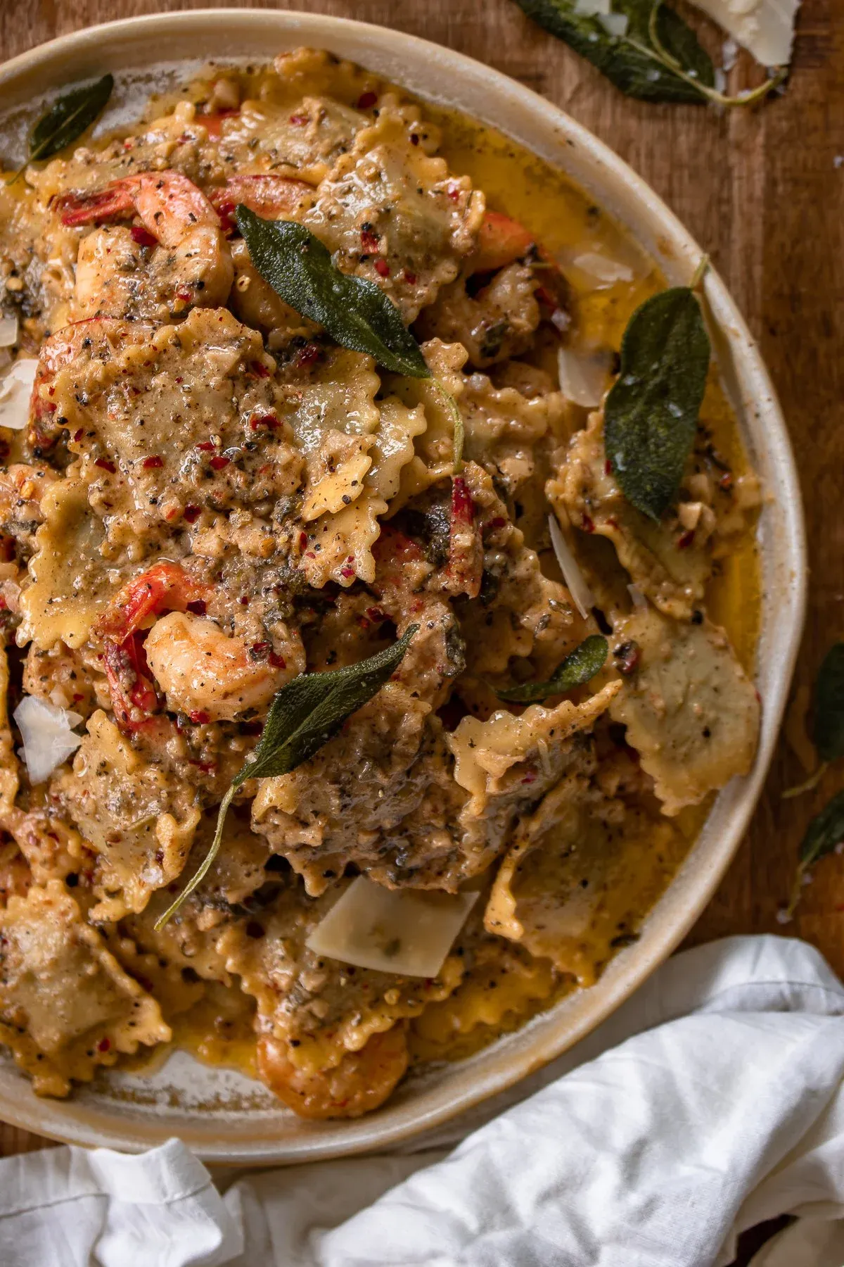 Angled overhead close-up of the bowl of Sage and Browned Butter Shrimp Scampi with Ravioli