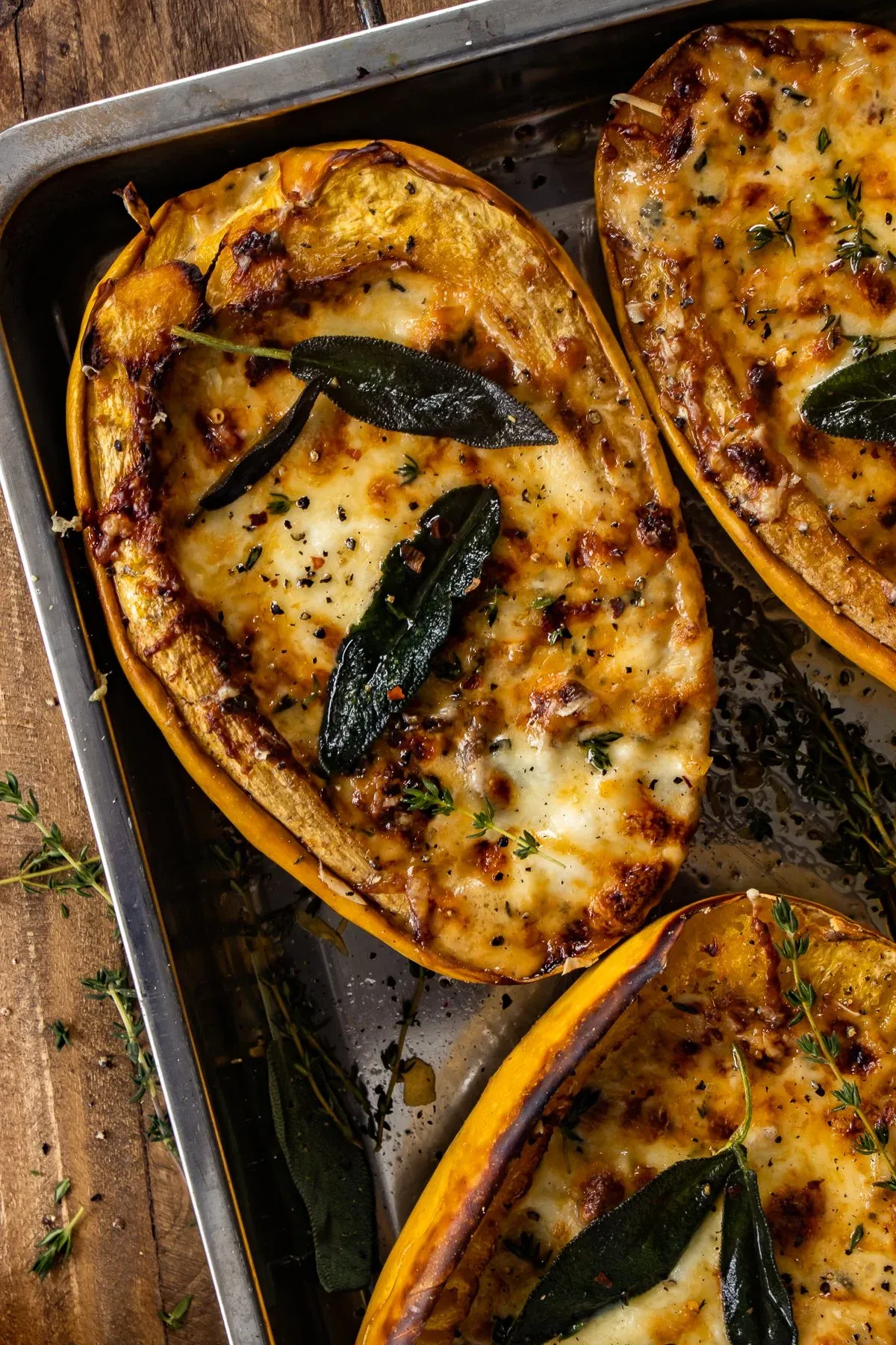 Close angled overhead shot of mushroom-cream stuffed spaghetti squash halves fresh from a metal baking pan