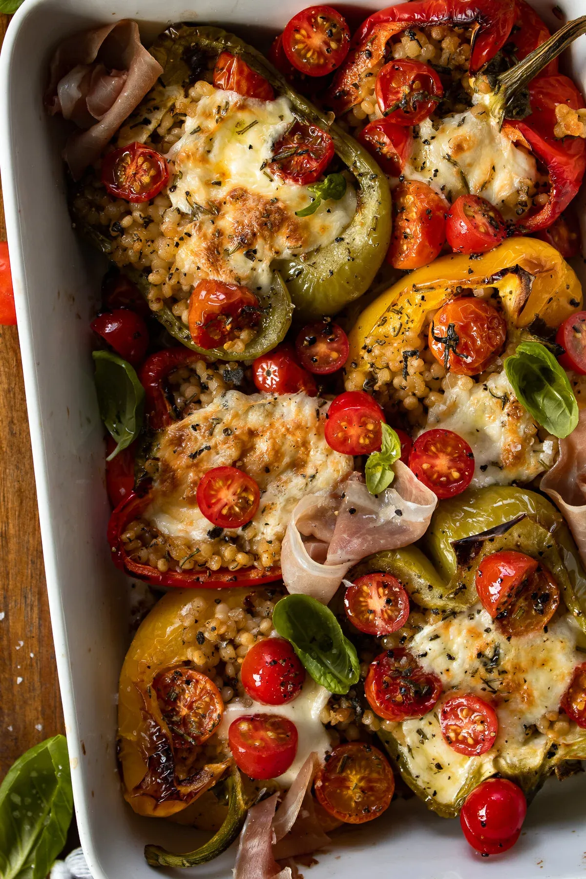 Close overhead view of the Couscous Stuffed Roasted Bell Peppers in the white baking dish
