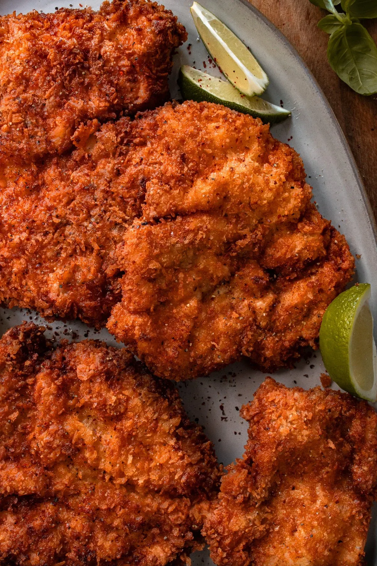 Angled overhead close-up of the panko-crusted mojo chicken katsu cutlets on the grey ceramic platter