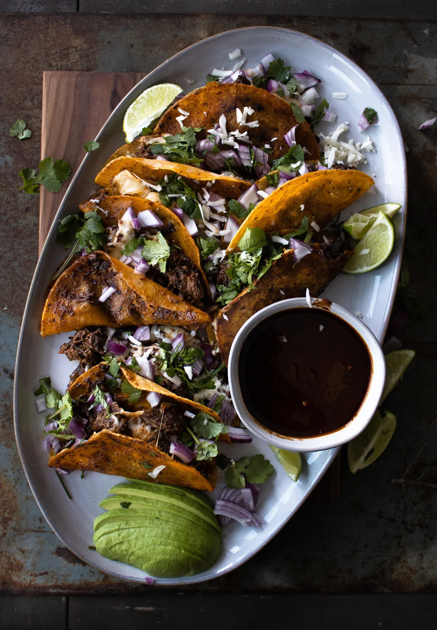 Overhead view of a white oval serving platter holding six Not Birria Beef Tacos in two rows
