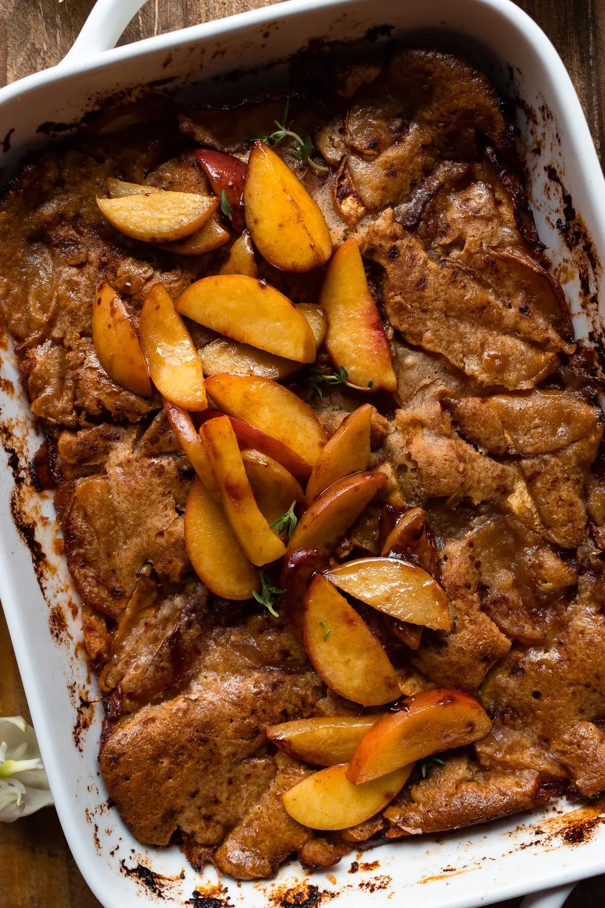 Angled overhead close-up of Brown Butter Peach Cobbler in the white baking dish without ice cream
