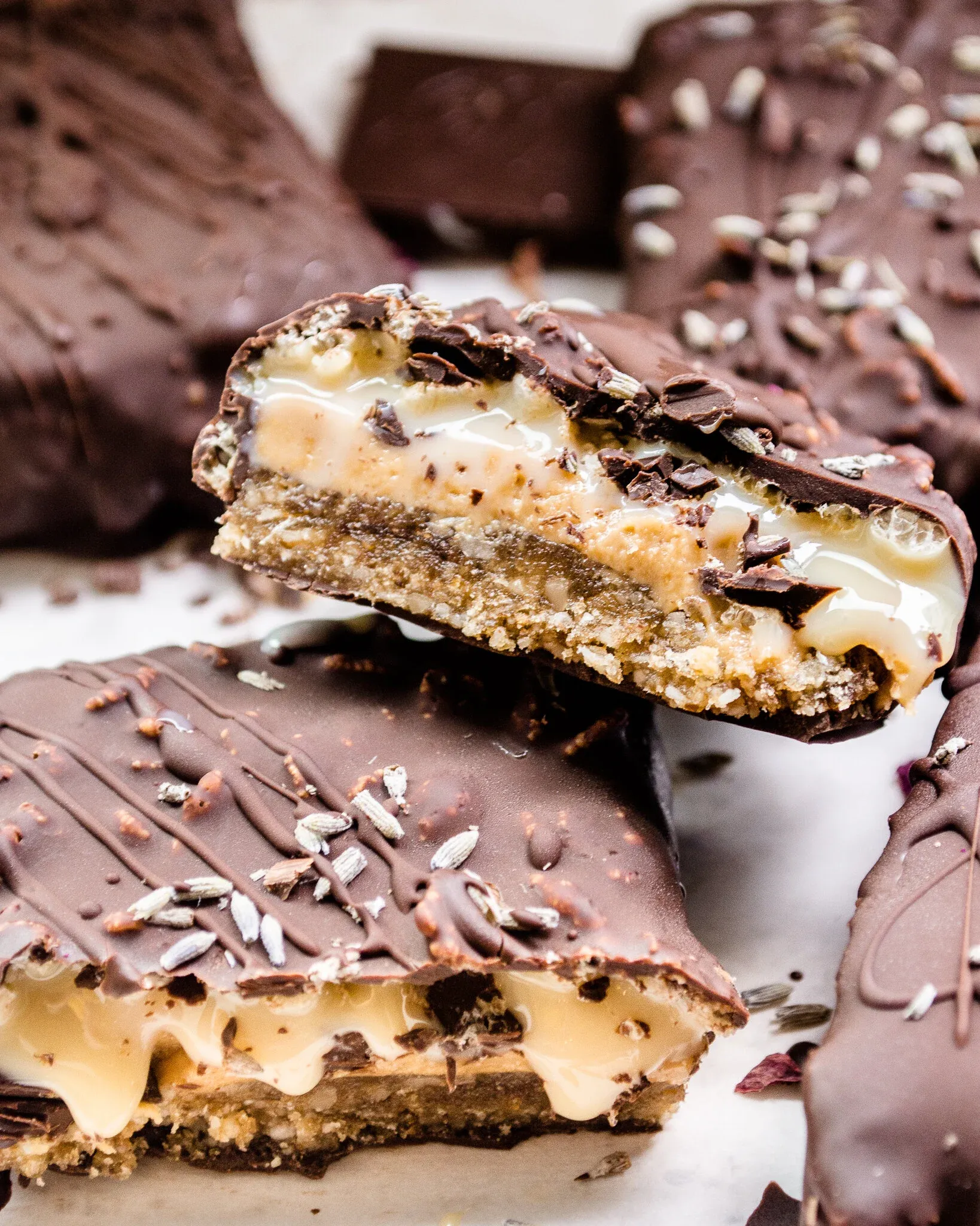 Angled close-up of a No-Bake Dulce De Leche Peanut Butter Crunch Bar propped upright showing its layered cross-section