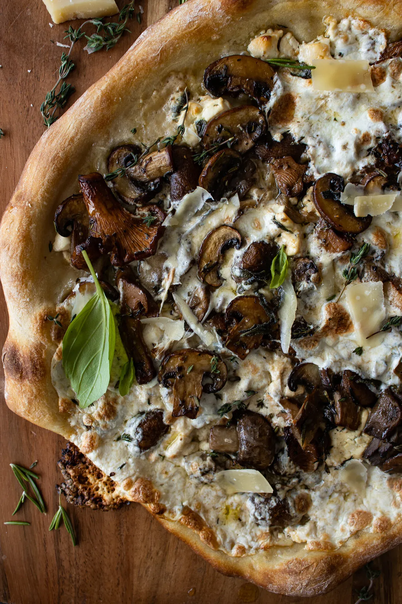 Close-up overhead shot of the Mushroom and Goat Cheese Pizza surface showing ruffled chanterelle mushrooms and sliced