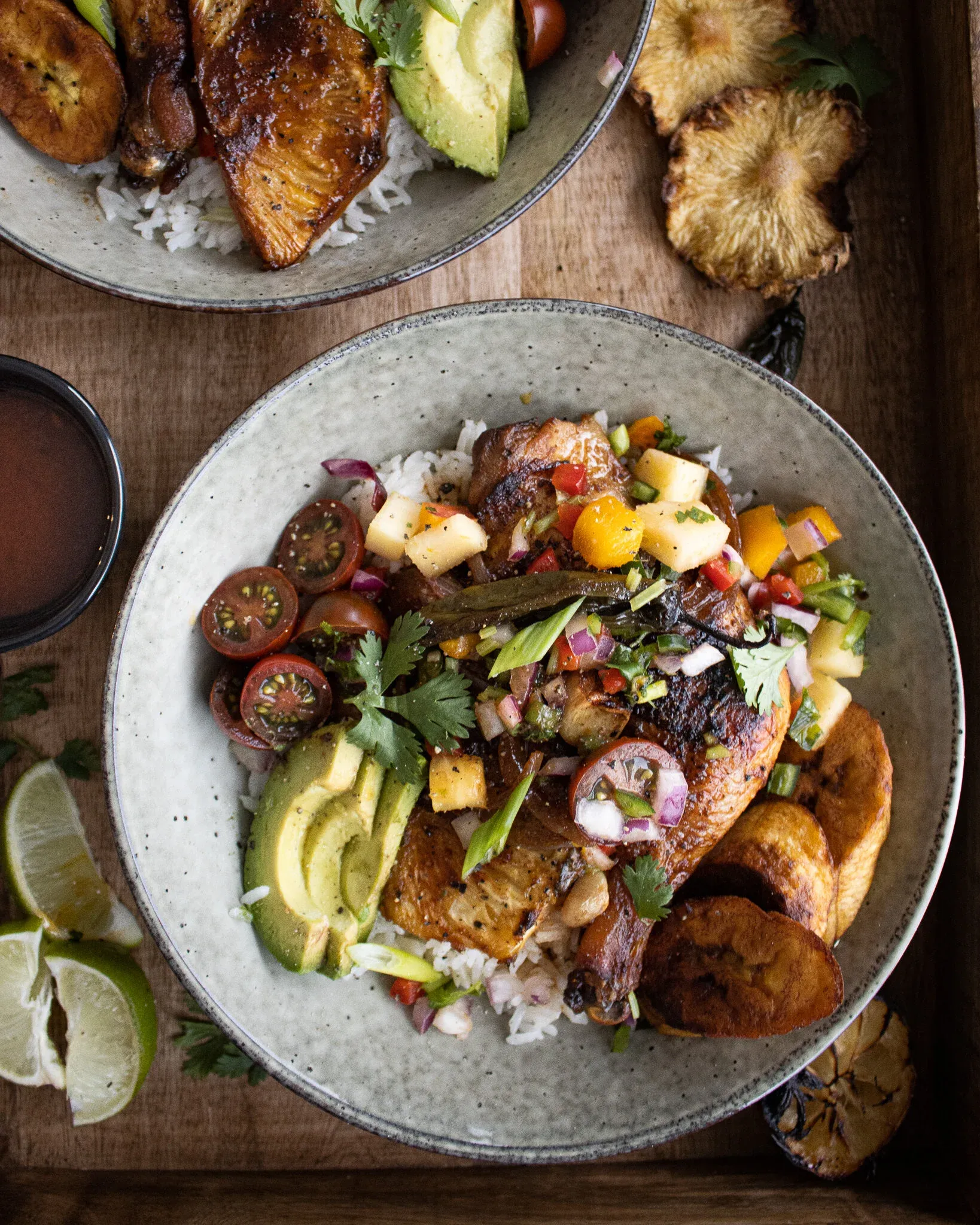 Closer overhead shot of one gray speckled Sheet Pan Pineapple Chicken Bowl in the foreground