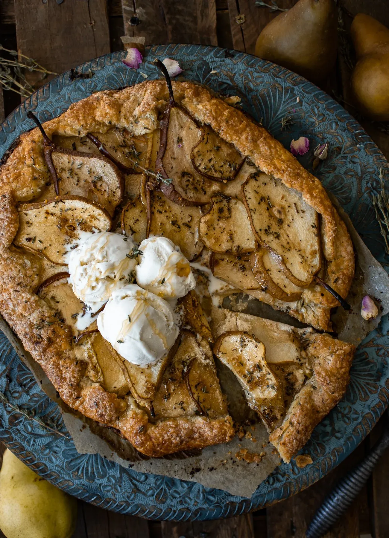Overhead shot of the sliced Pear and Mascarpone Thyme Galette on the teal decorative plate showing cut lines radiating from the center