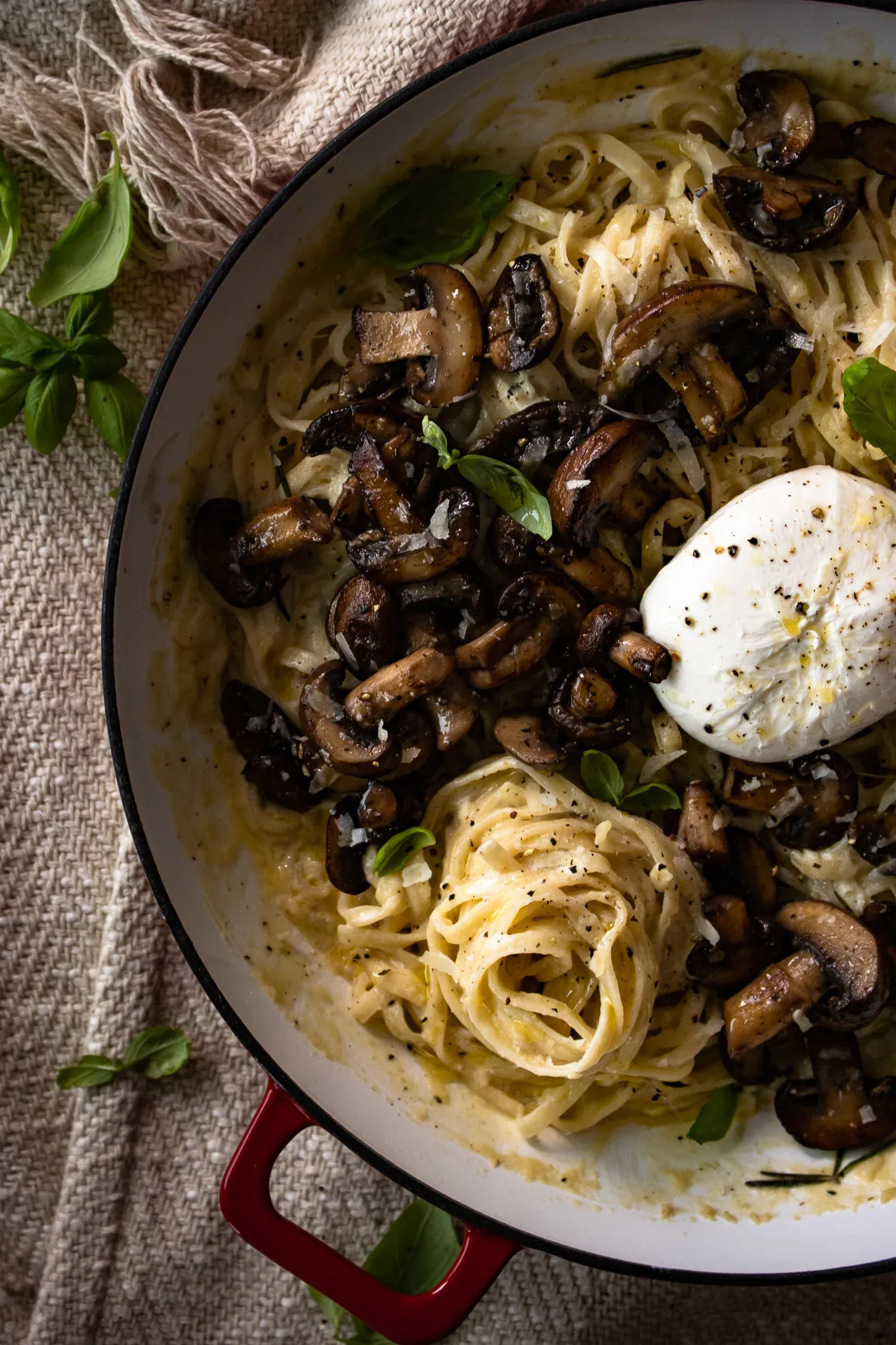 Angled overhead close-up of the white enamel skillet of White Wine Pasta with Roasted Mushrooms