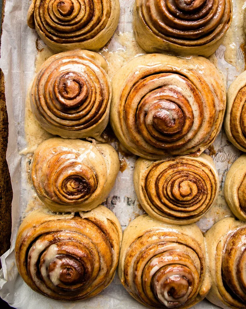 Close overhead crop of eight cinnamon rolls in the center and right portion of the baking pan