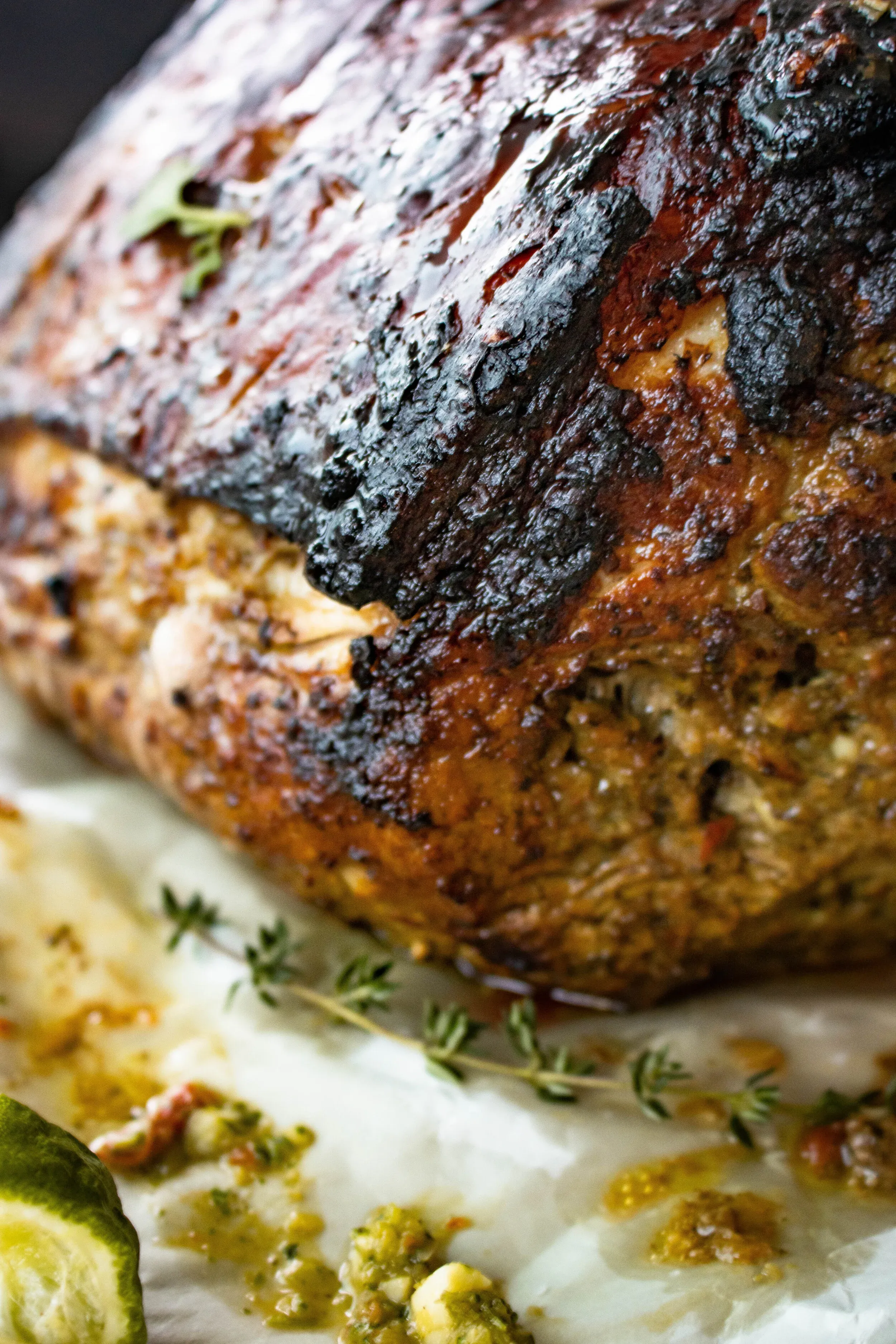 Extreme close-up side view of the puerco asado's exterior crust, revealing the deeply caramelized