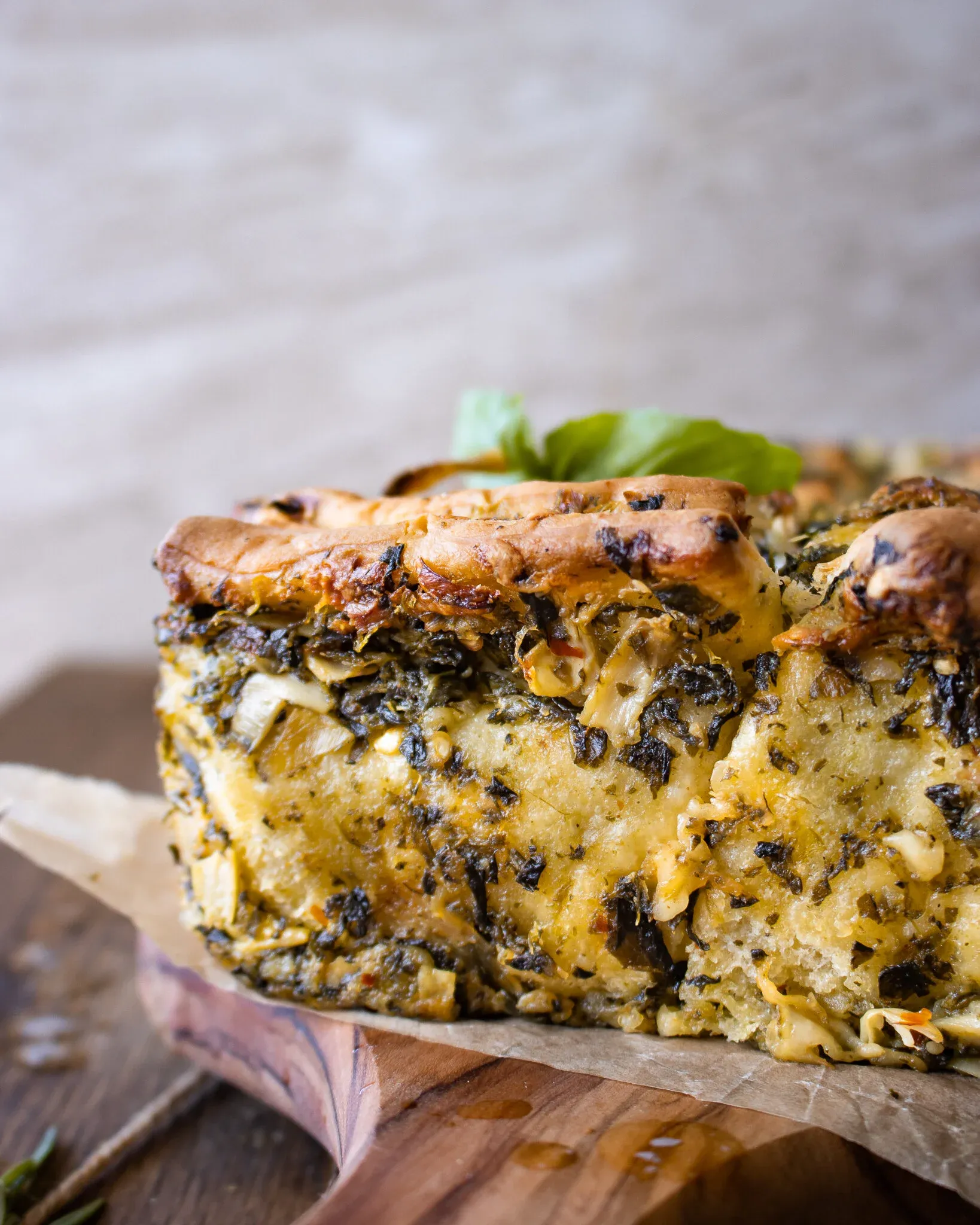 Close-up side view of a cross-section of pesto spinach and artichoke pull-apart bread showing the interior layers