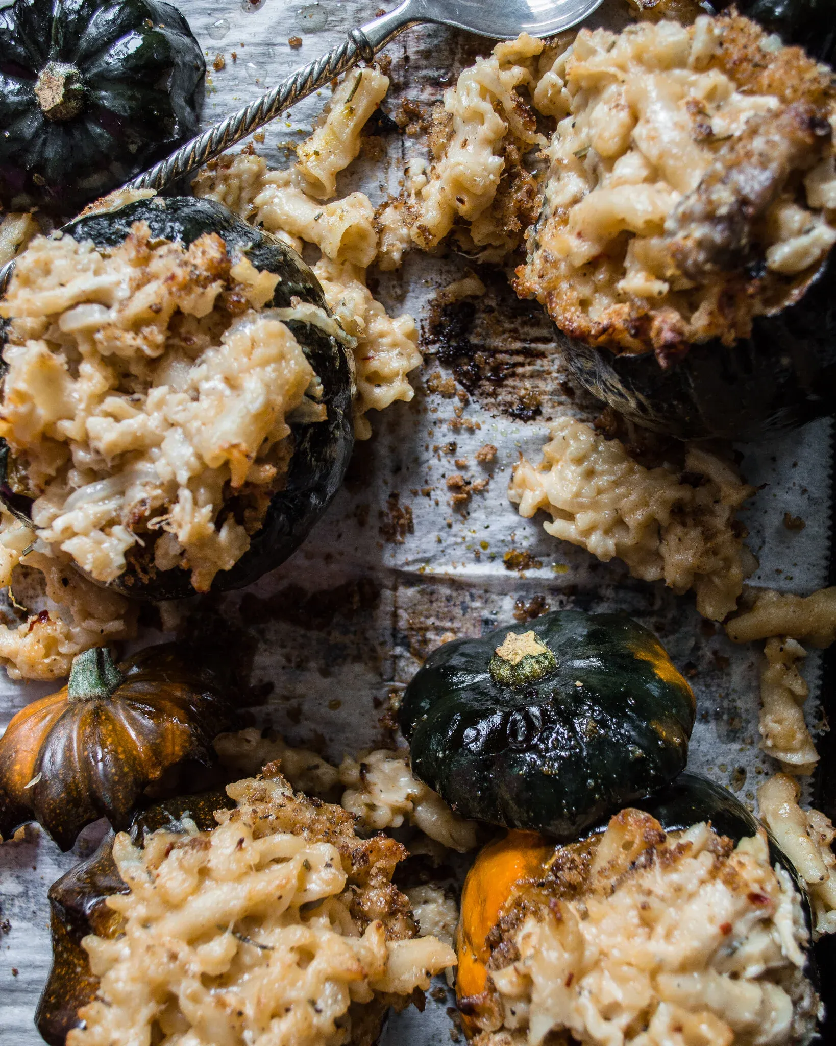 Wide overhead shot of the full baking sheet showing multiple Crab Mac and Cheese Stuffed Acorn Squash halves