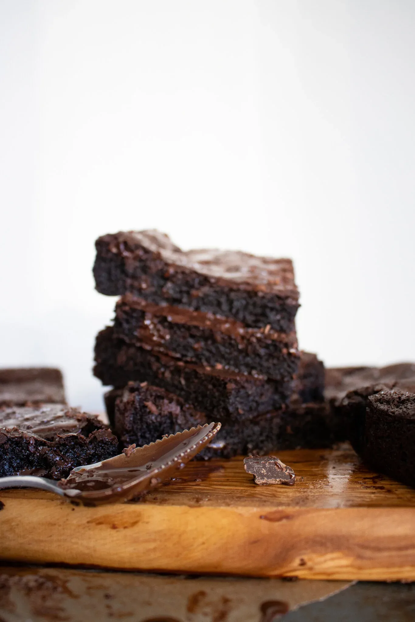 Wider side-view of the Vegan Dark Chocolate Brownie stack on a live-edge cutting board