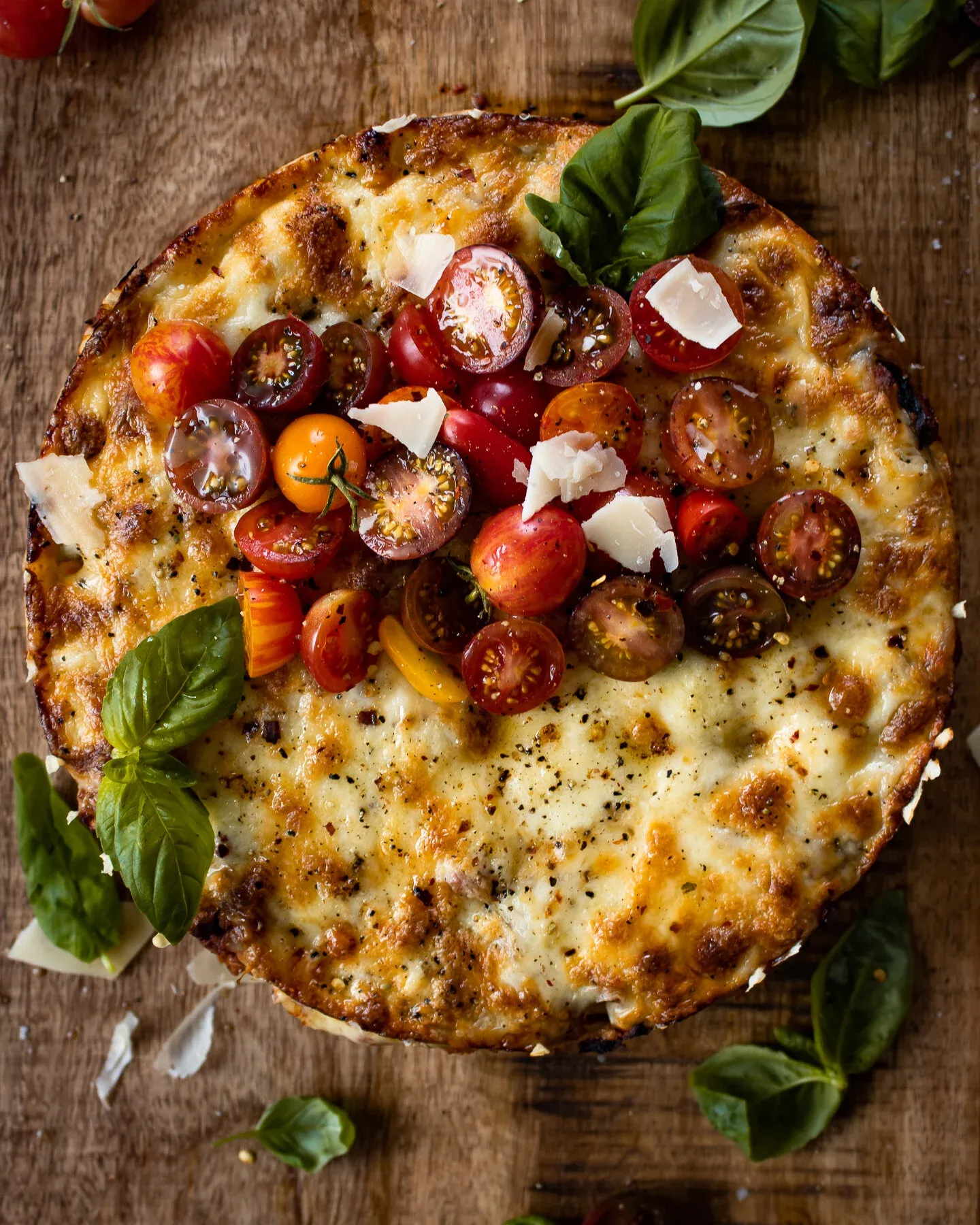 Wide overhead shot of the finished Rigatoni Pasta Pie on a weathered wooden board