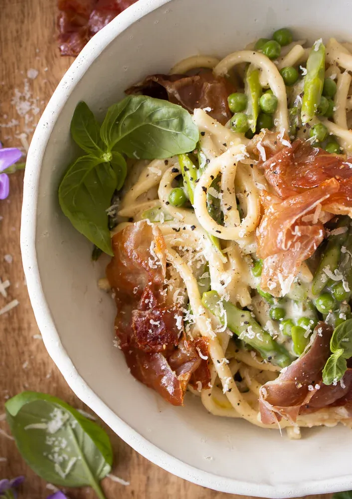 Overhead angled close-up of the Cacio e Pepe with Spring Veggies and Crispy Prosciutto bowl