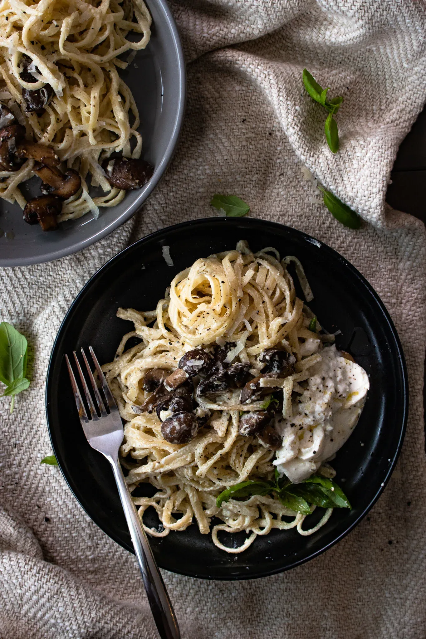 Overhead flat-lay of two plated servings of White Wine Pasta with Roasted Mushrooms