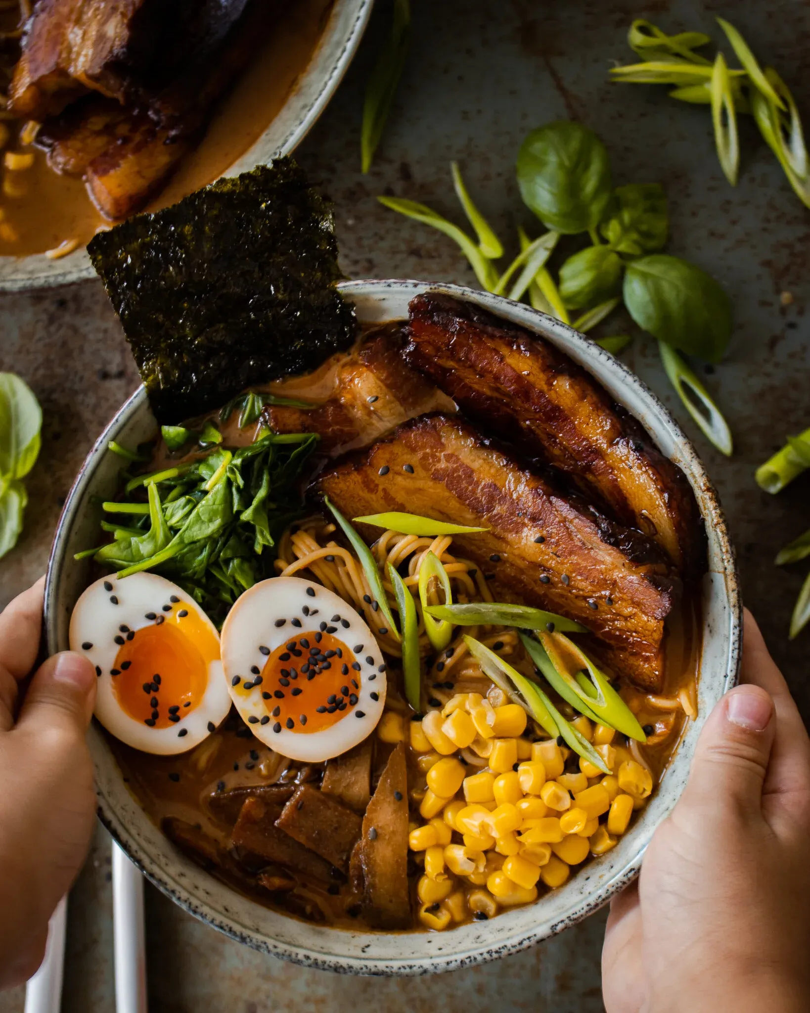 Two hands cradling a steaming bowl of Use What You Have Ramen from below