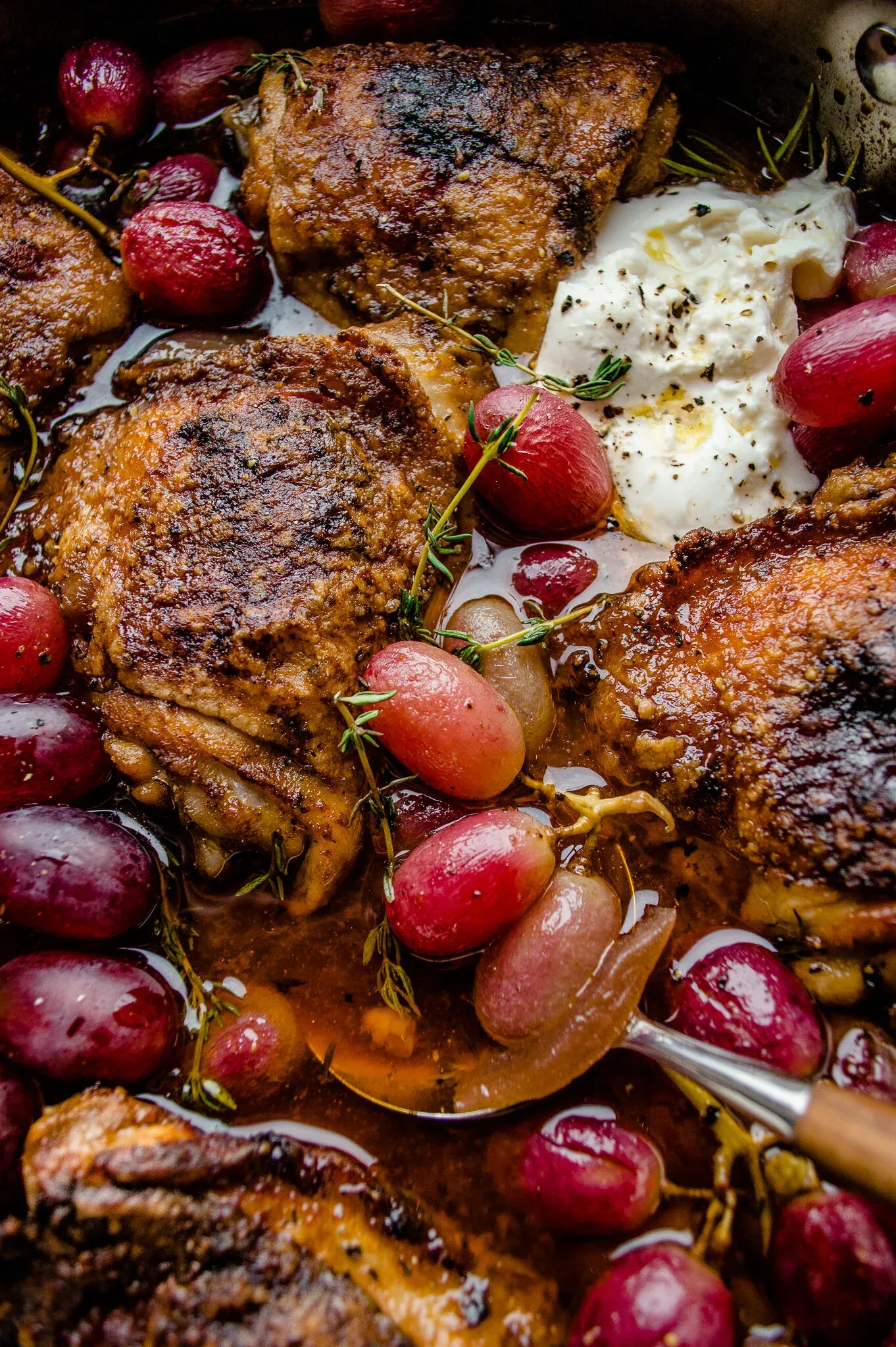 Close-up shot inside the stainless pan of red wine and balsamic braised chicken thighs