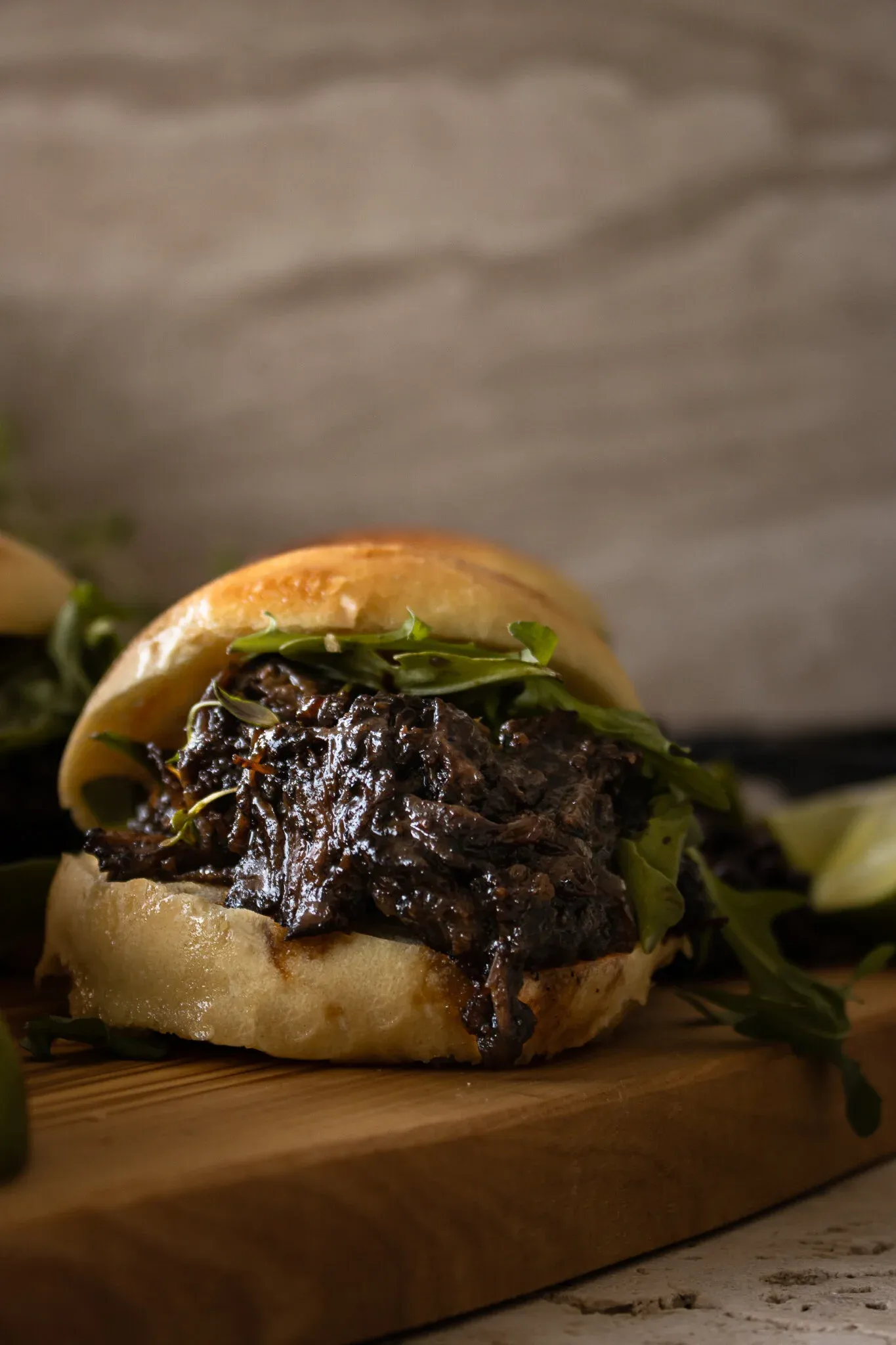 Single BBQ Beef Slider on a small wooden cutting board