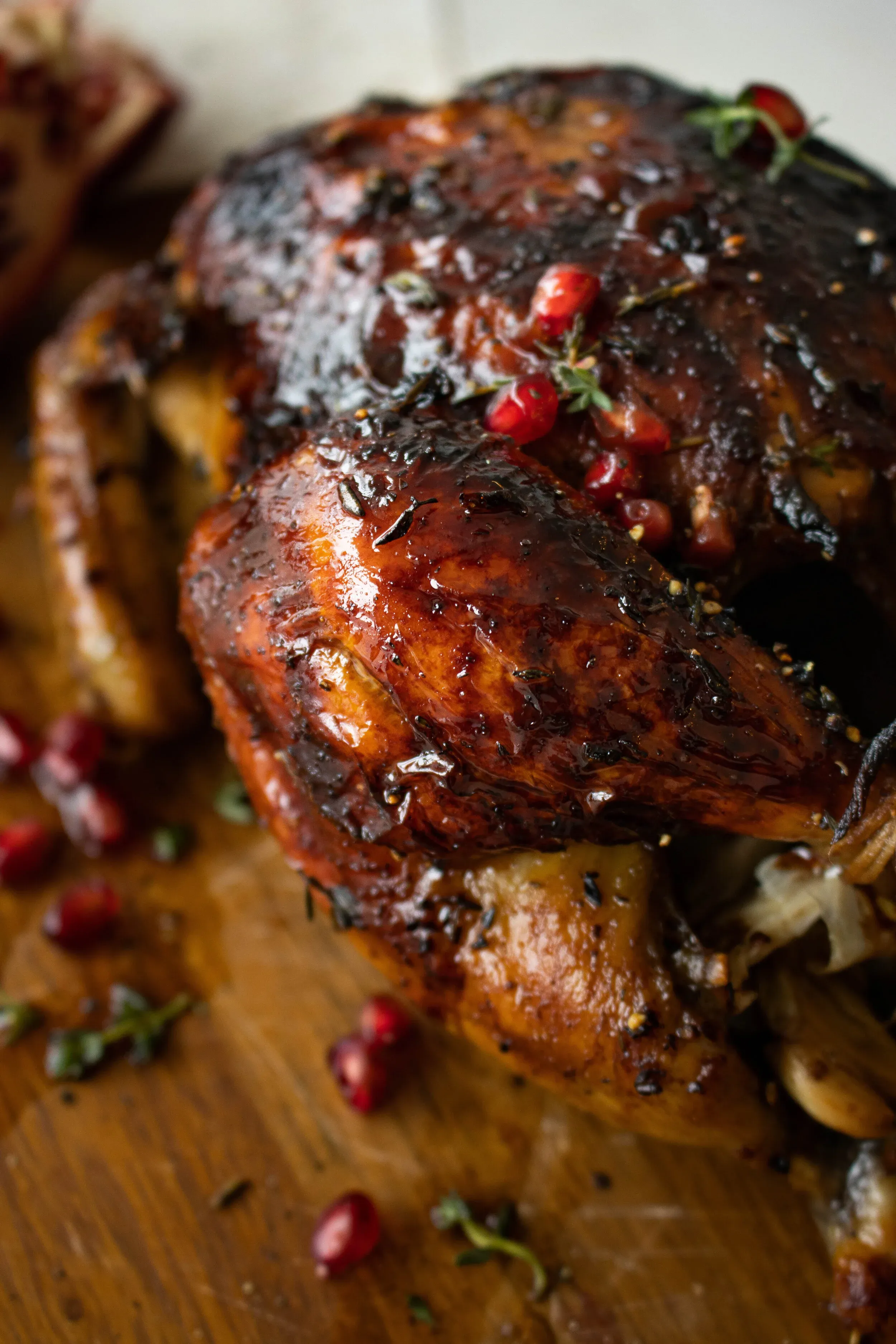 Extreme close-up of carved Balsamic and Pomegranate Roasted Chicken pieces showing the intensely glossy lacquered dark mahogany balsamic glaze coating the skin
