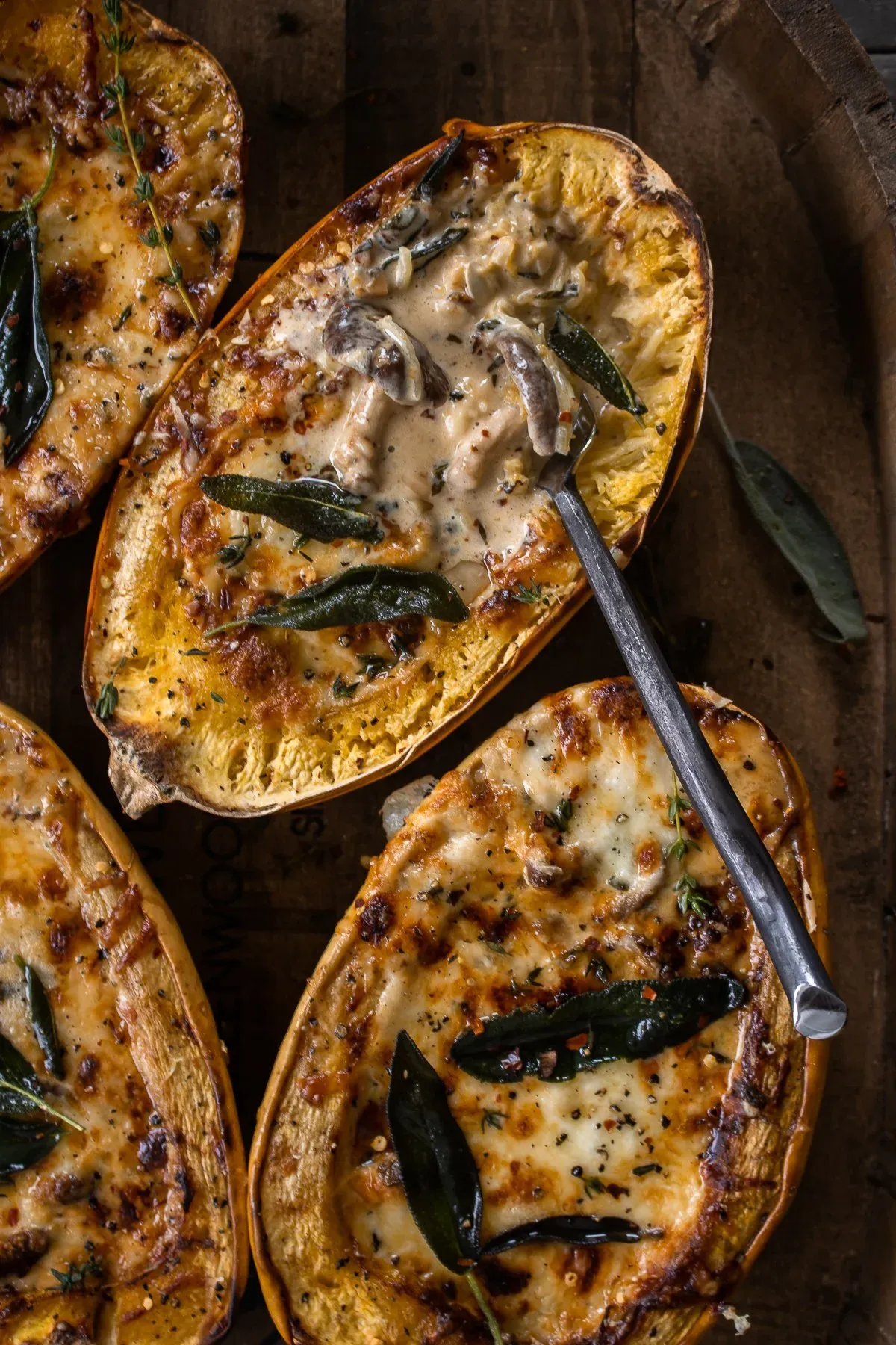Angled close-up of spaghetti squash halves on a rustic wooden tray