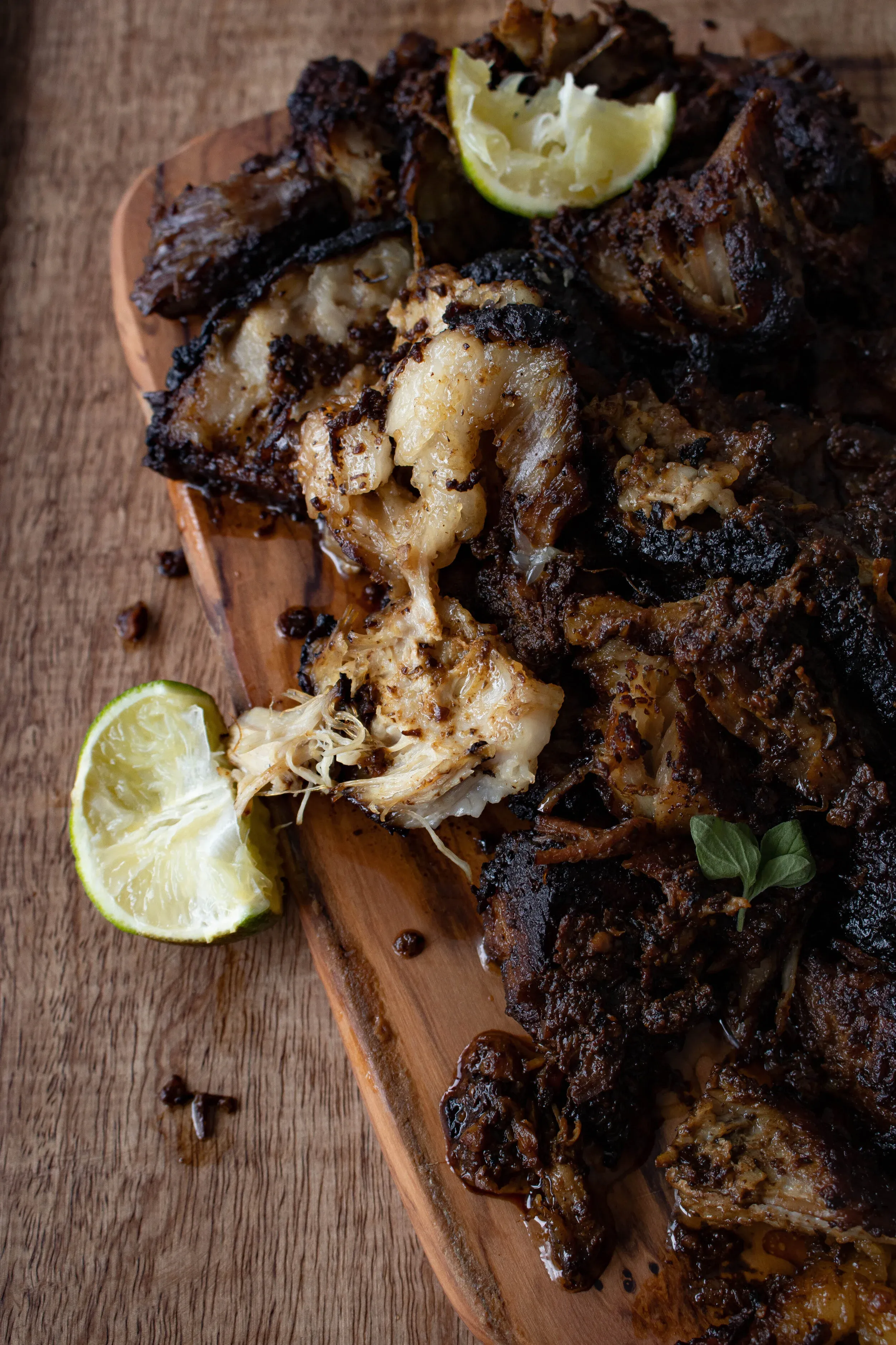 Angled close-up of shredded puerco asado on the wooden cutting board