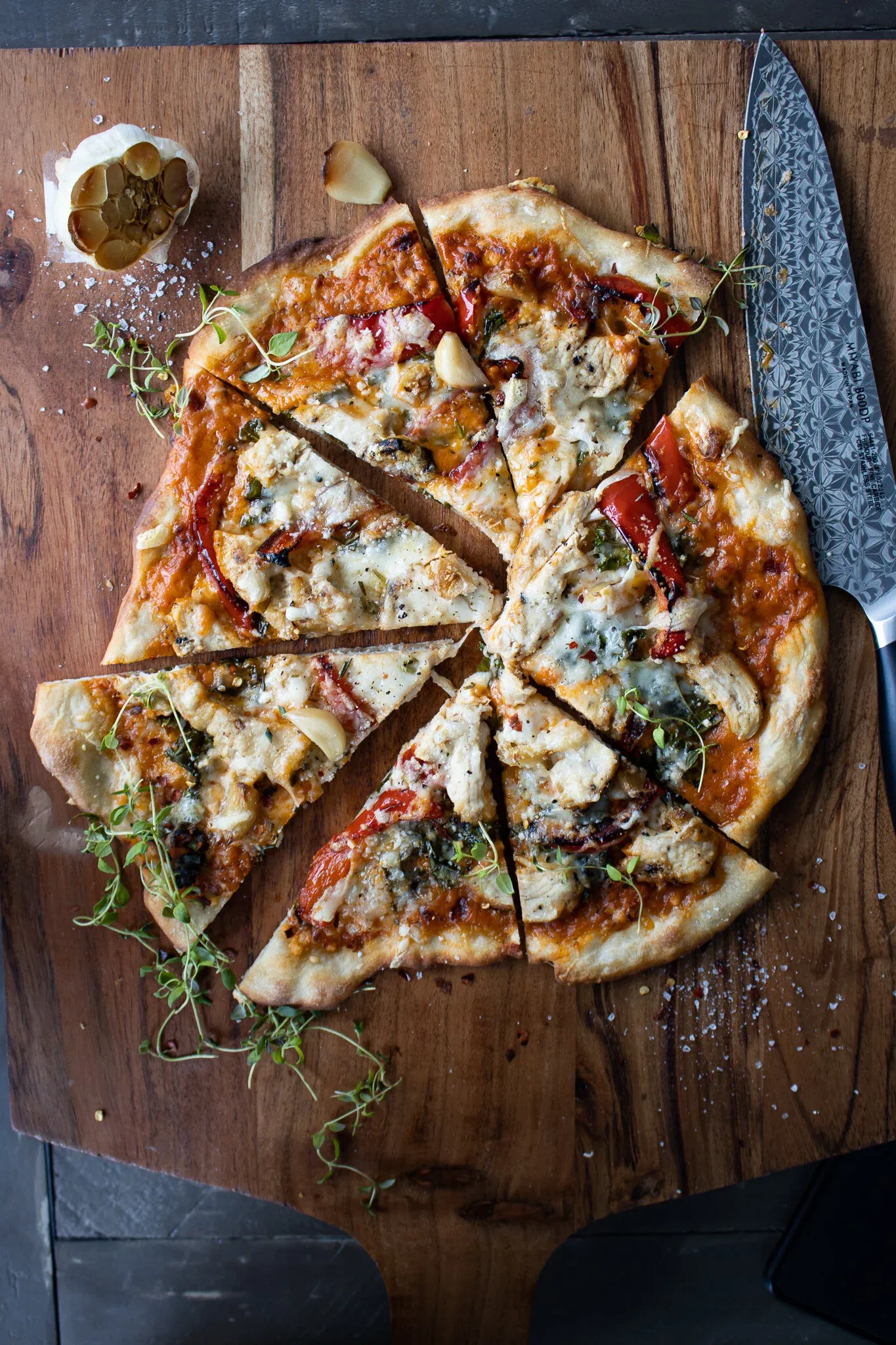 Overhead view of the sliced chicken alla vodka pizza on a round wooden pizza peel