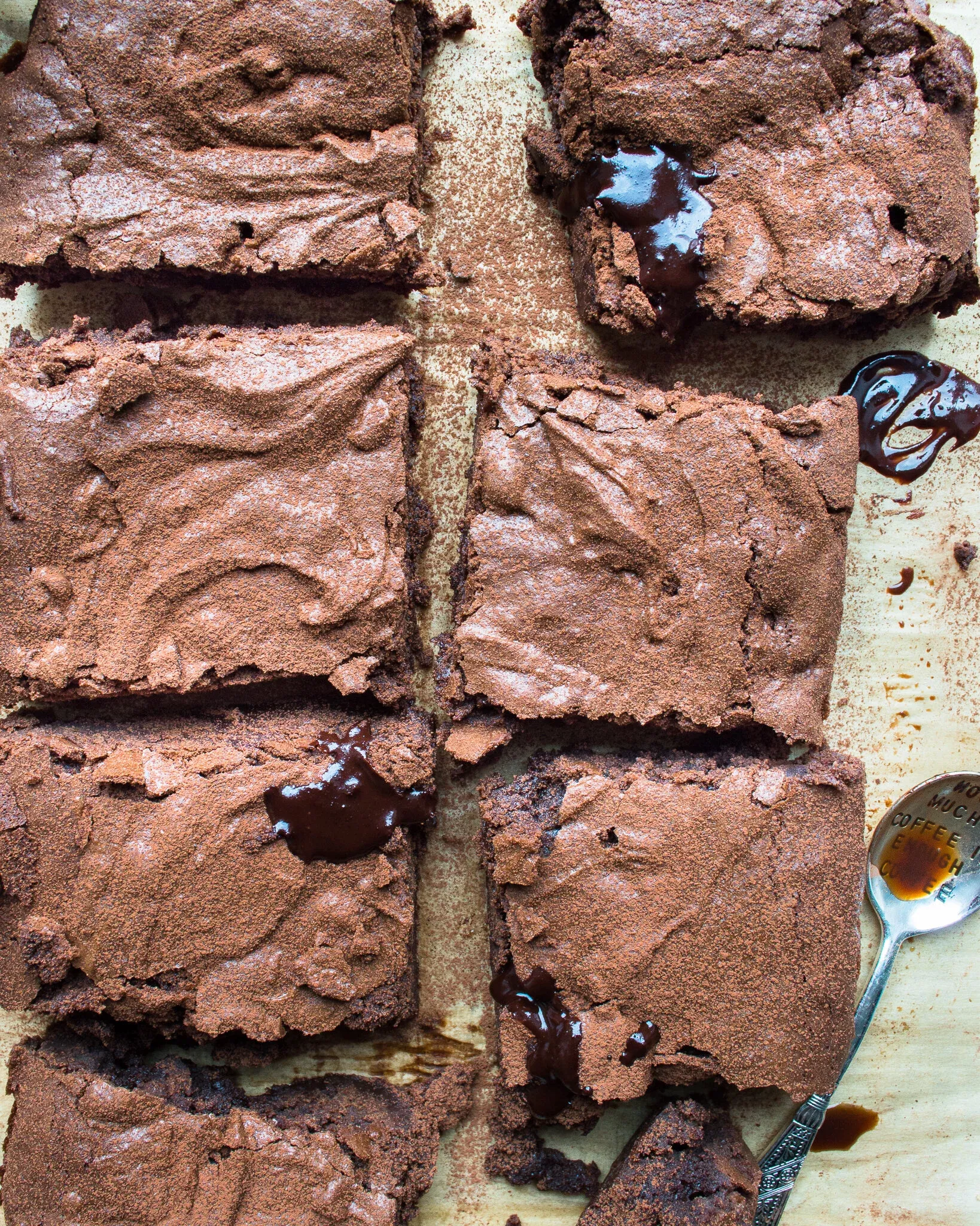 Six rectangular gluten free espresso brownies arranged on parchment paper viewed directly overhead