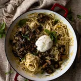 Overhead shot of White Wine Pasta with Roasted Mushrooms in a large white enamel skillet with red handles