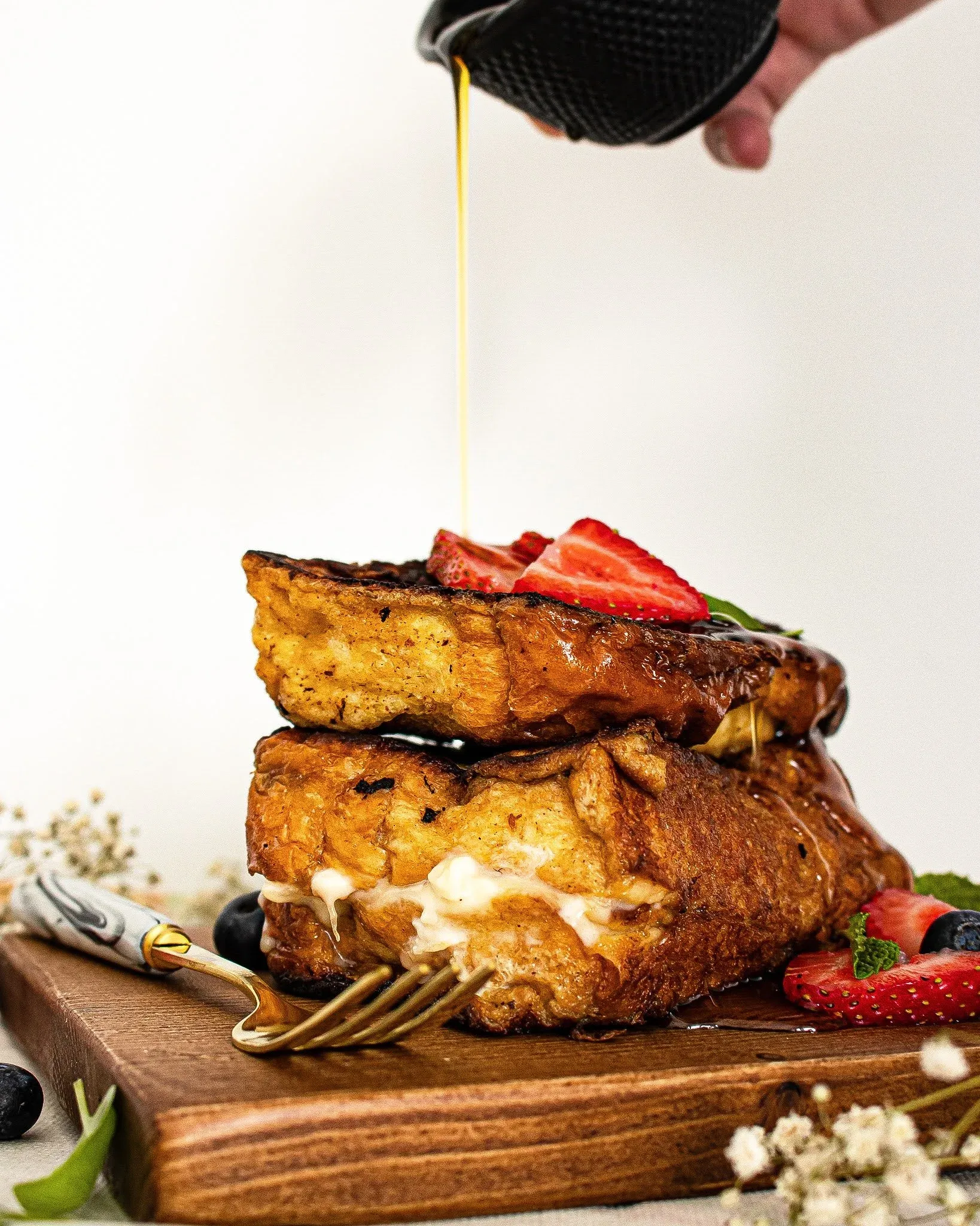 Mascarpone Stuffed French Toast stacked two slices high on a wooden cutting board