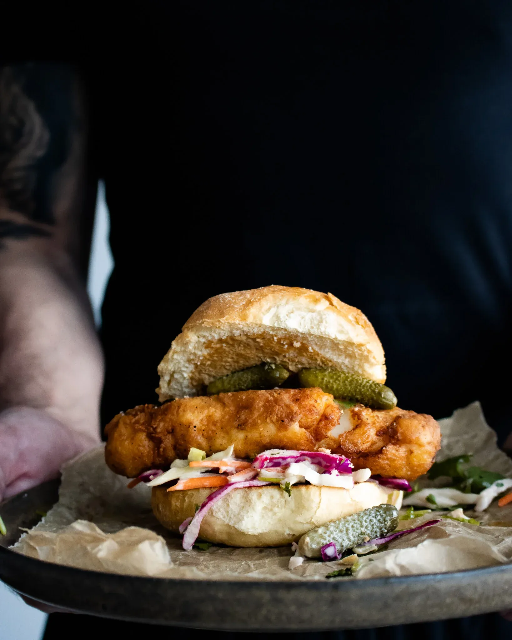 Crispy beer-battered fried cod sandwich stacked on a soft toasted brioche bun