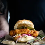 Crispy beer-battered fried cod sandwich stacked on a soft toasted brioche bun