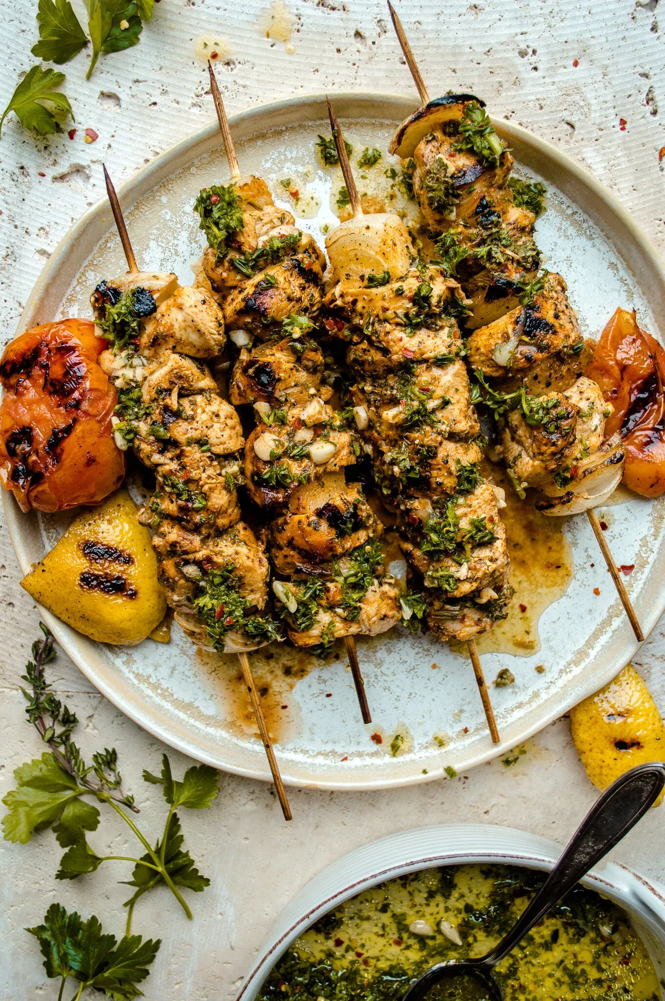 Five Citrus and Mojo Marinated Grilled Chicken Skewers fanned across a rustic white ceramic plate