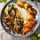 Oyster Mushroom Vaca Frita plated on a vintage blue-gray floral ceramic dish on a weathered white wood surface