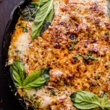 Overhead close-up of Eggplant Involtini baked in a black cast iron skillet