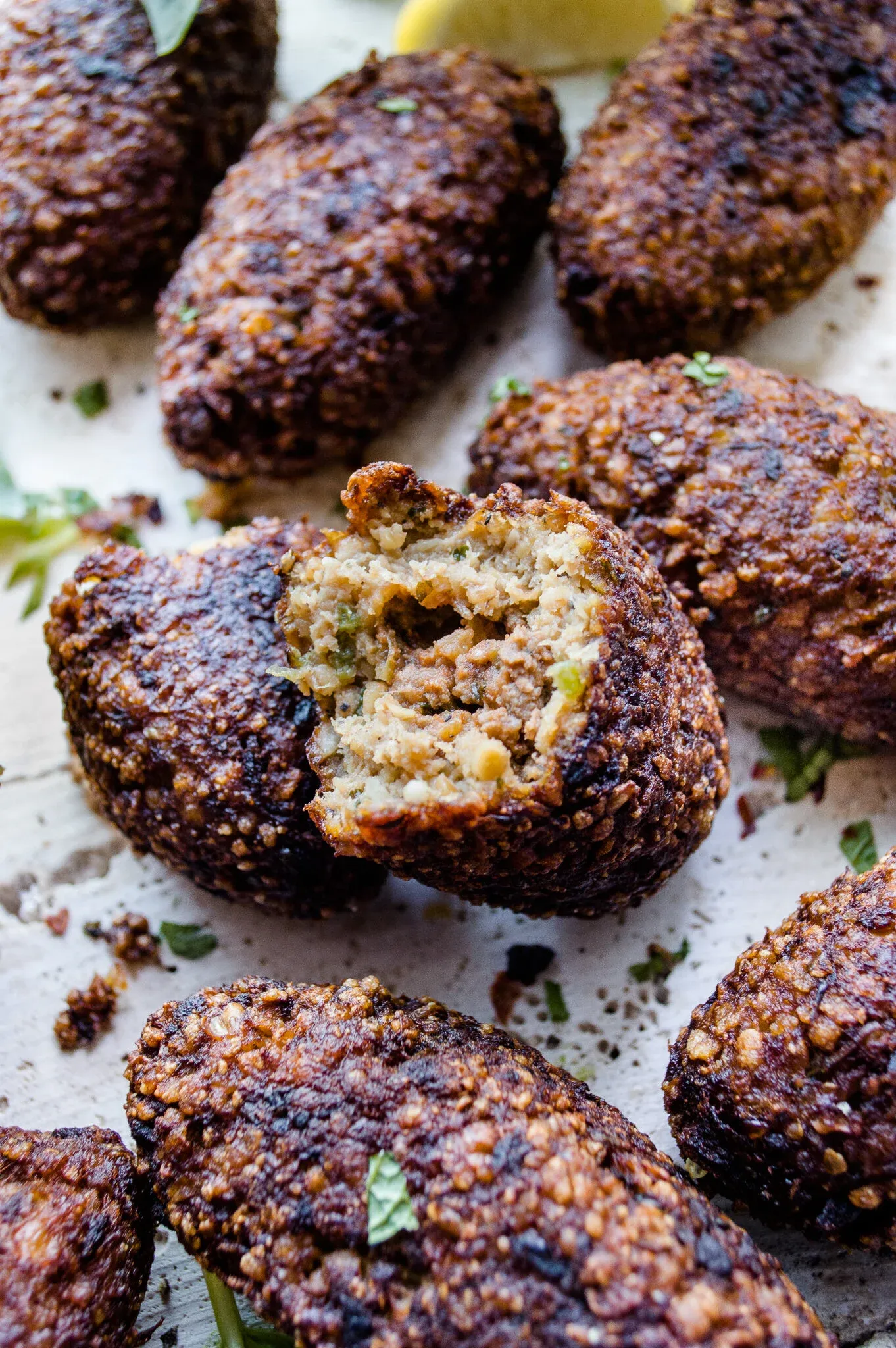 Several Dominican Quipe (Kipe) fritters clustered together on a white surface