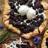 Overhead shot of a large Berry Galette with Honey Goat Cheese topped with two scoops of softly melting ice cream