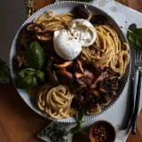 White Wine Pasta with Roasted Mushroom in a large white beaded-rim bowl on a white tray