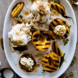 Overhead white oval platter of maple brown butter stuffed grilled peaches
