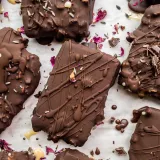 Overhead flat-lay of multiple No-Bake Dulce De Leche Peanut Butter Crunch Bars scattered on white parchment paper