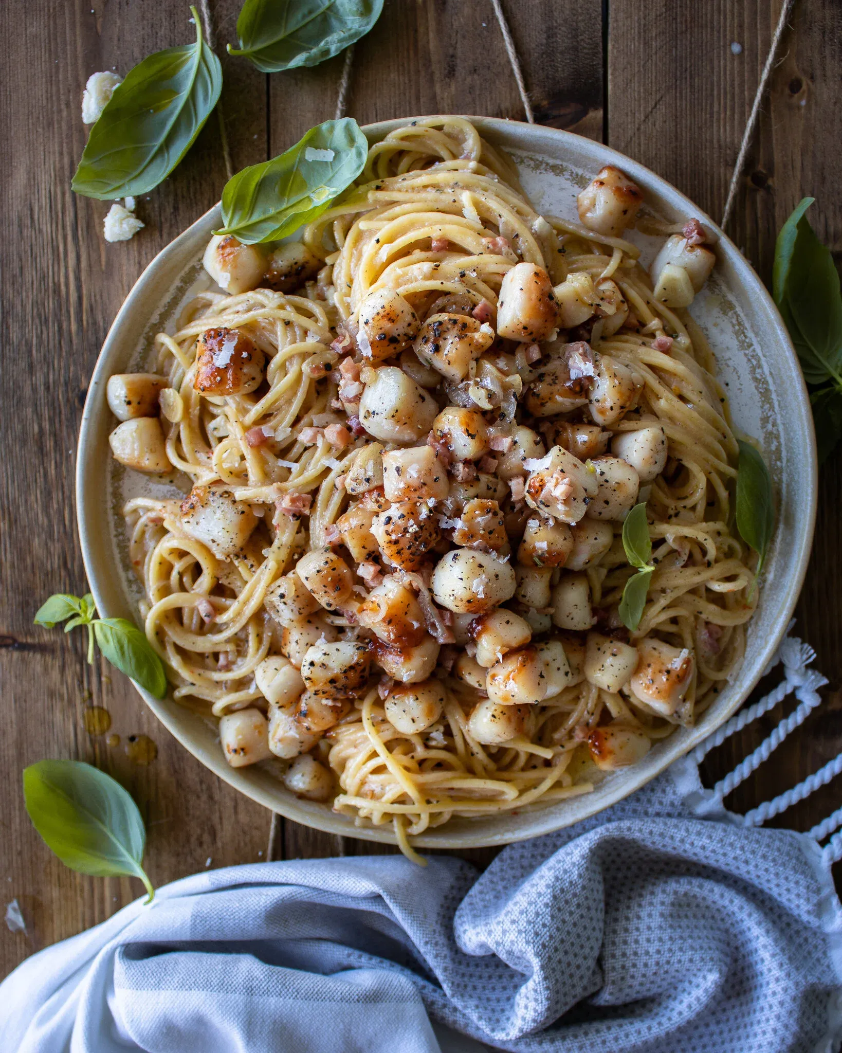 Overhead shot of a wide cream speckled ceramic plate piled with Garlic Butter Pasta with Seared Scallops