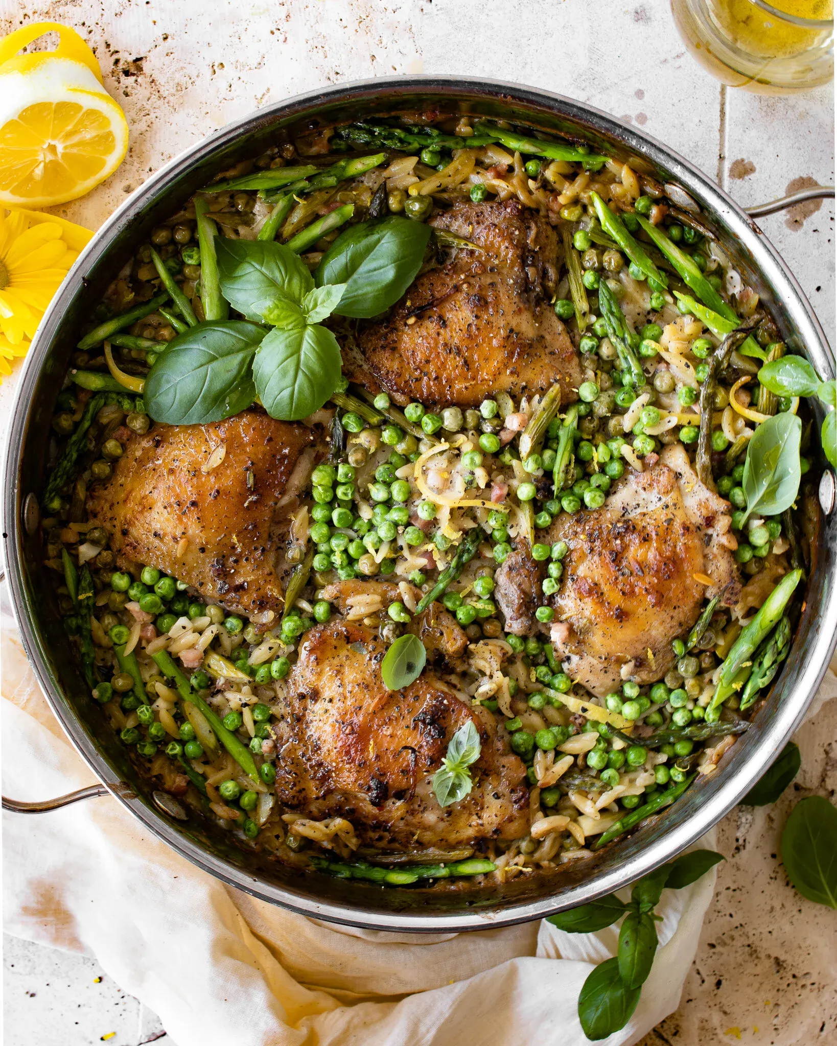 One Skillet Chicken and Orzo with Spring Veggies in a large stainless steel two-handled pan