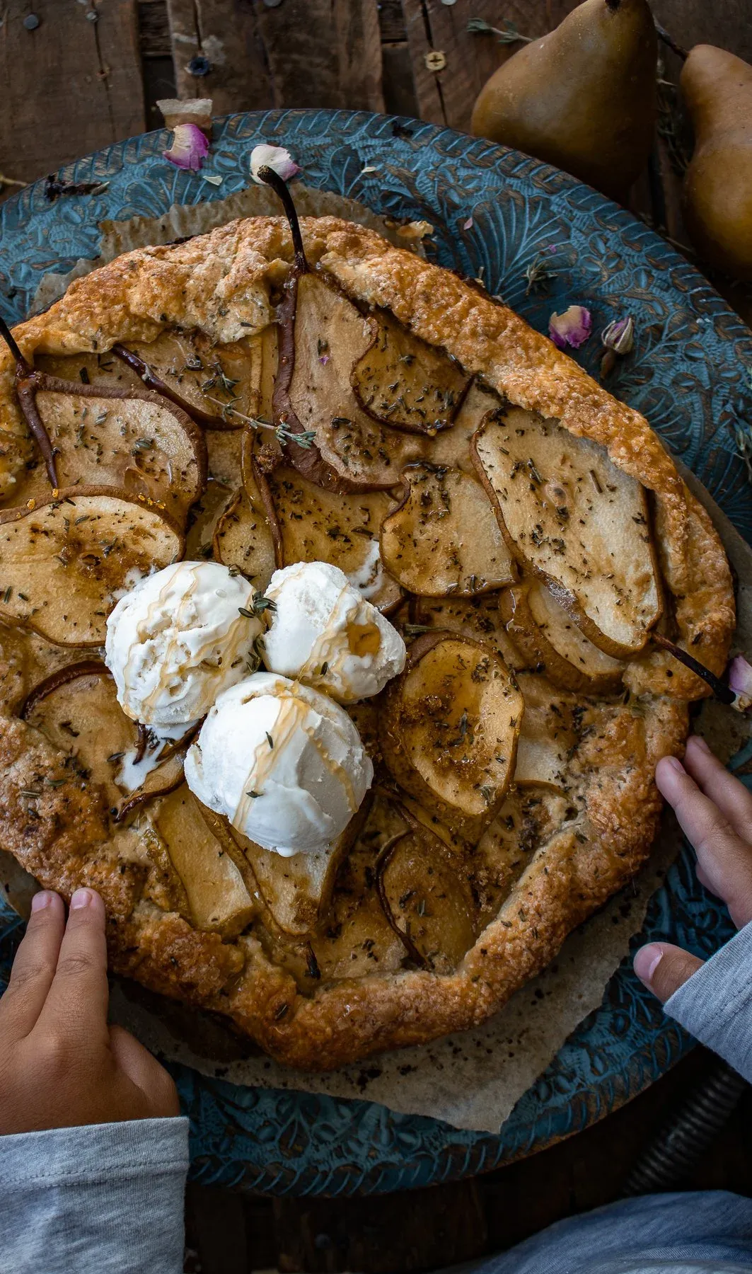 Pear and Mascarpone Thyme Galette on a decorative teal patina embossed metal charger plate on dark wood
