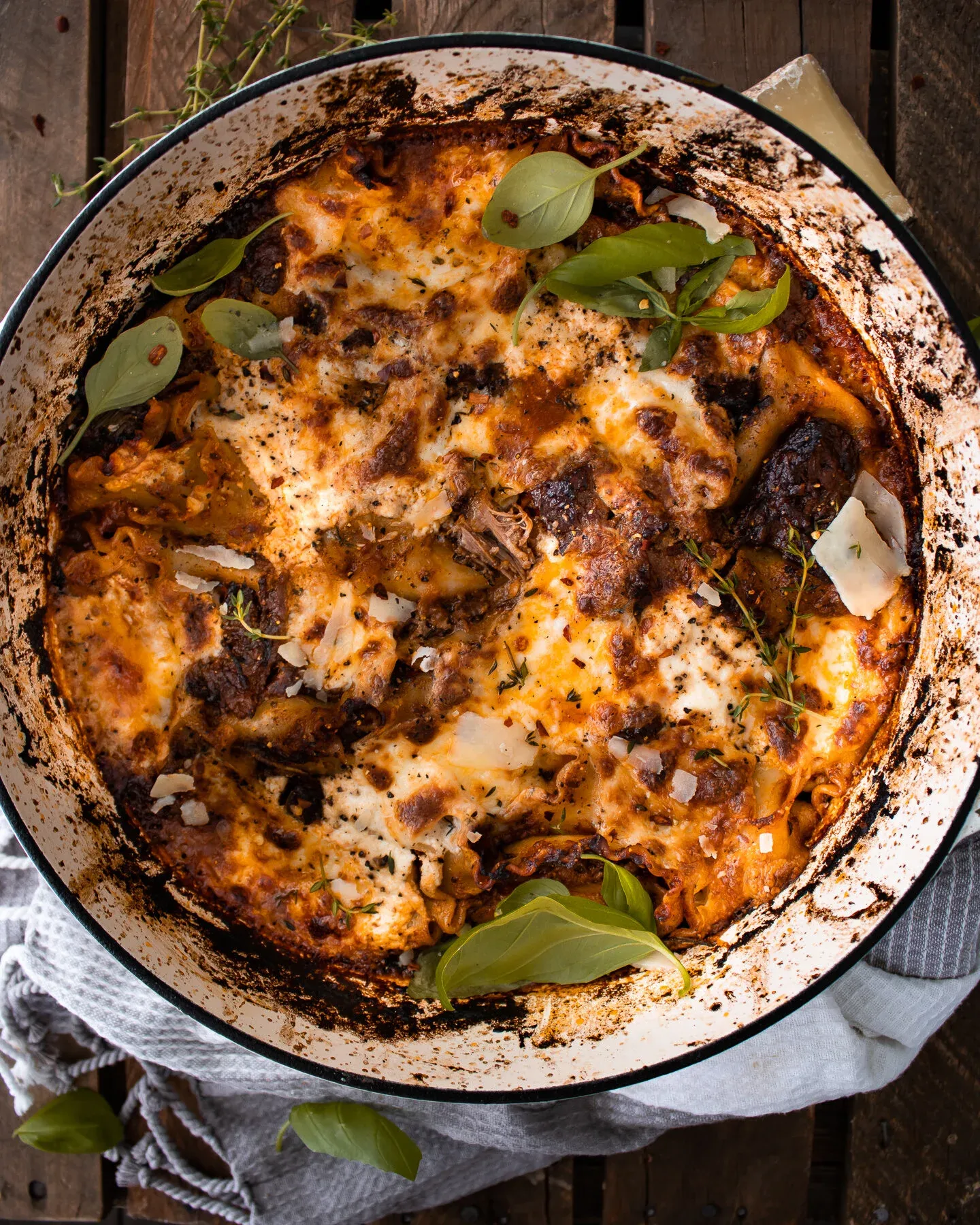 Short Rib Skillet Lasagna baked in a large round white enamel braiser with charred black rim