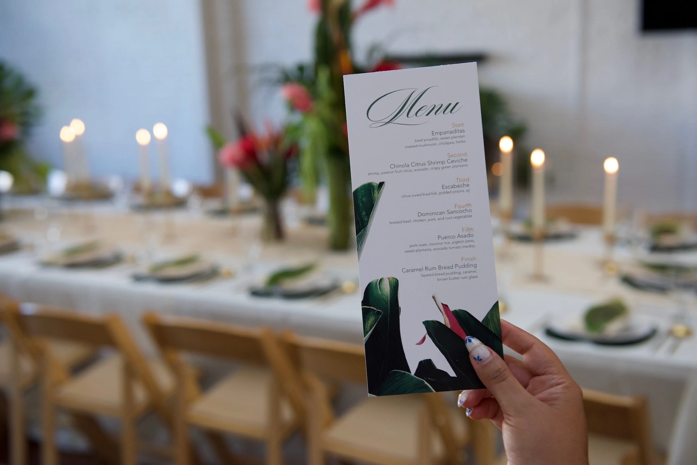 A printed multi-course dinner menu in front of the candlelit table