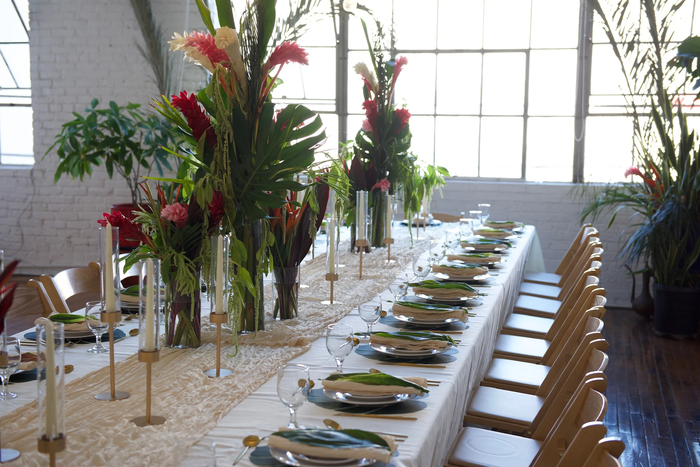 A bright dining table dressed with tropical flowers and place settings